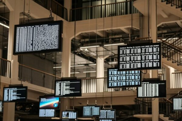 A bunch of television screens hanging from the ceiling