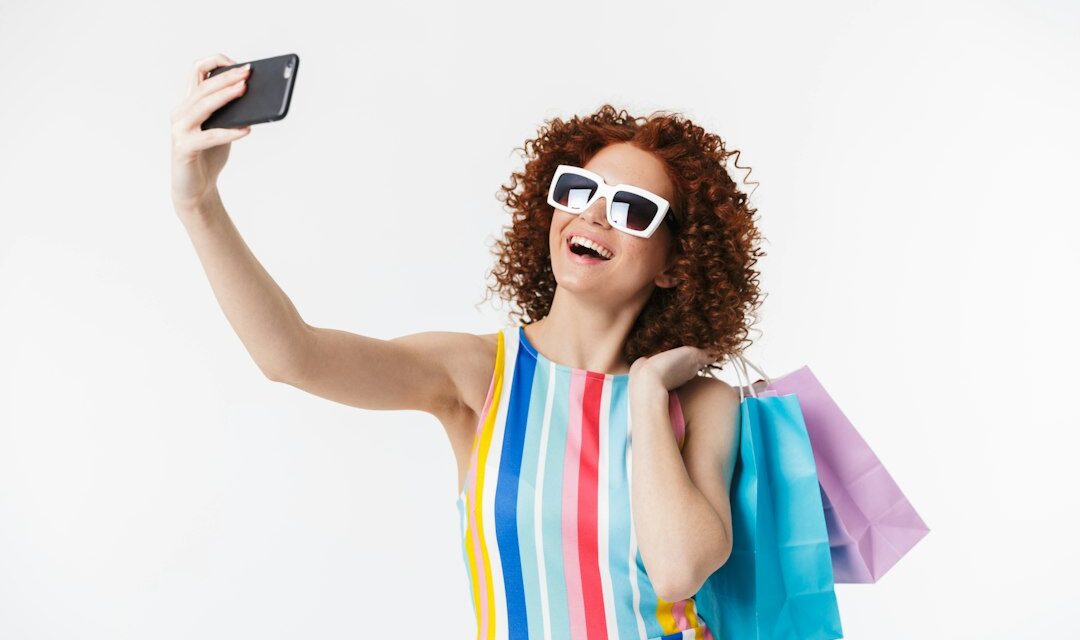 A woman wearing sunglasses and holding a cell phone