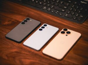 Three smartphones are on a wooden surface