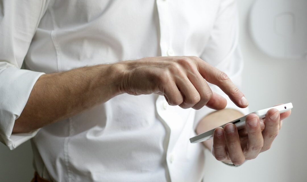 Person holding white Android smartphone in white shirt