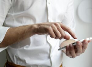 Person holding white Android smartphone in white shirt