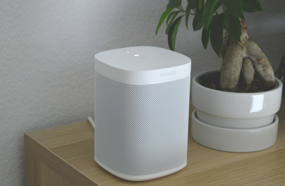 White portable speaker on brown wooden table