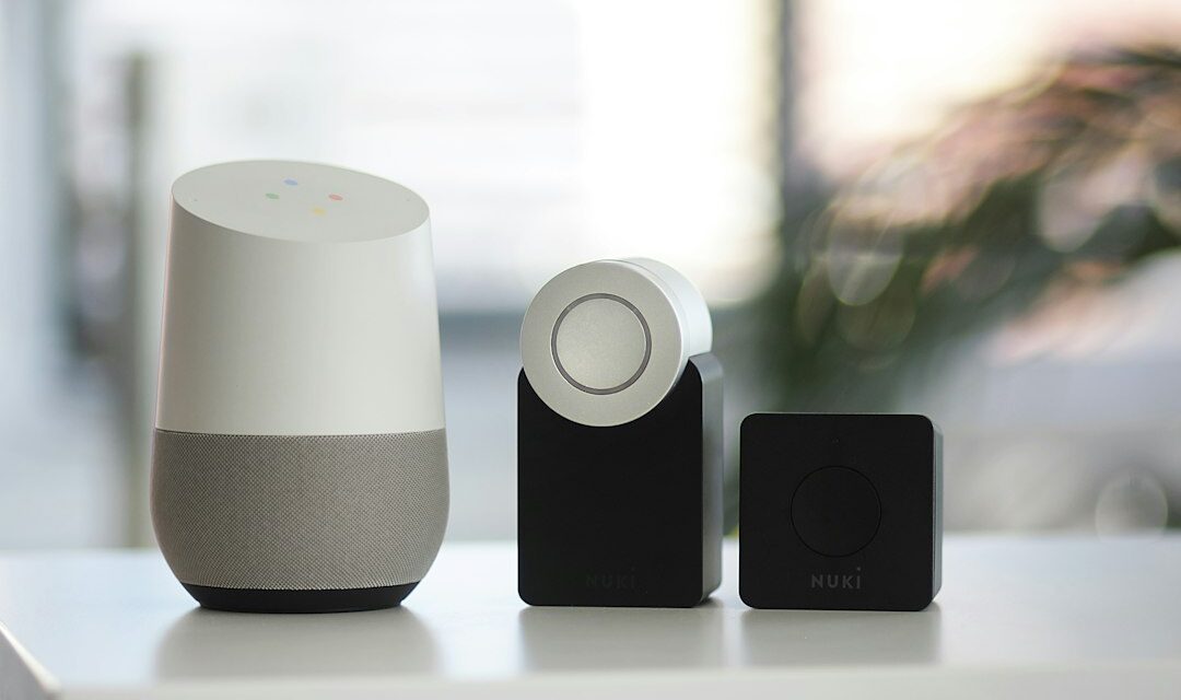 White and gray Google smart speaker and two black speakers