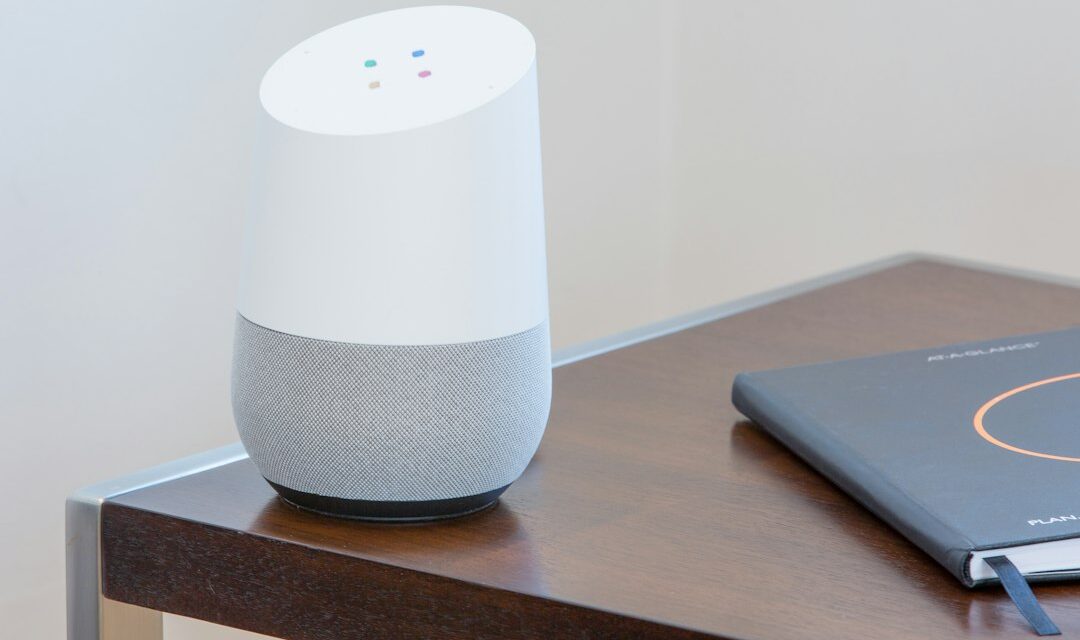 White and gray Google home on brown table