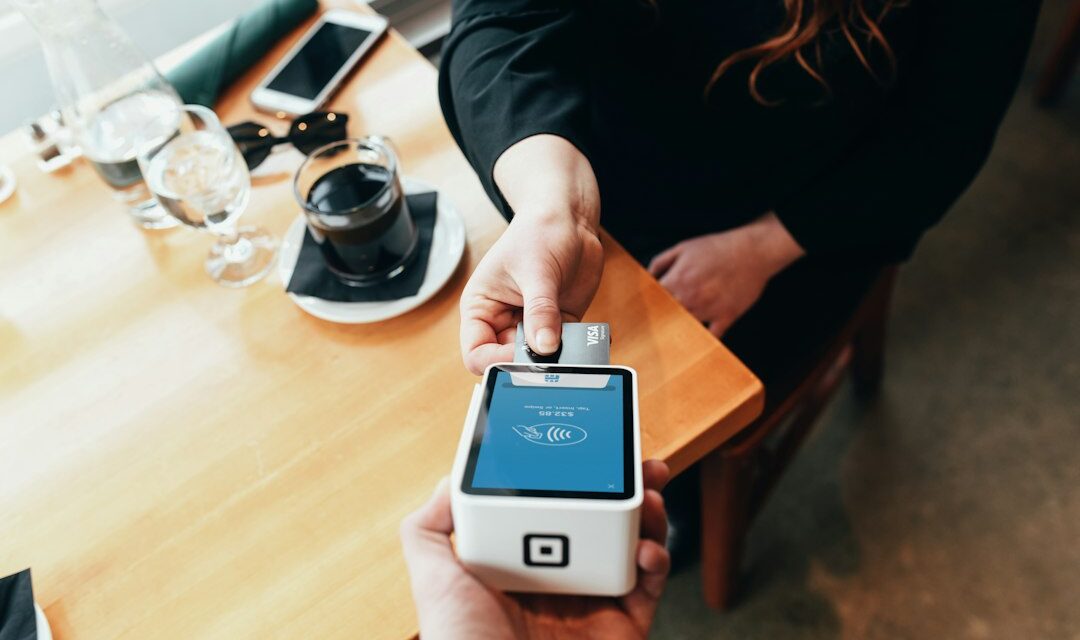 Person holding credit card swipe machine