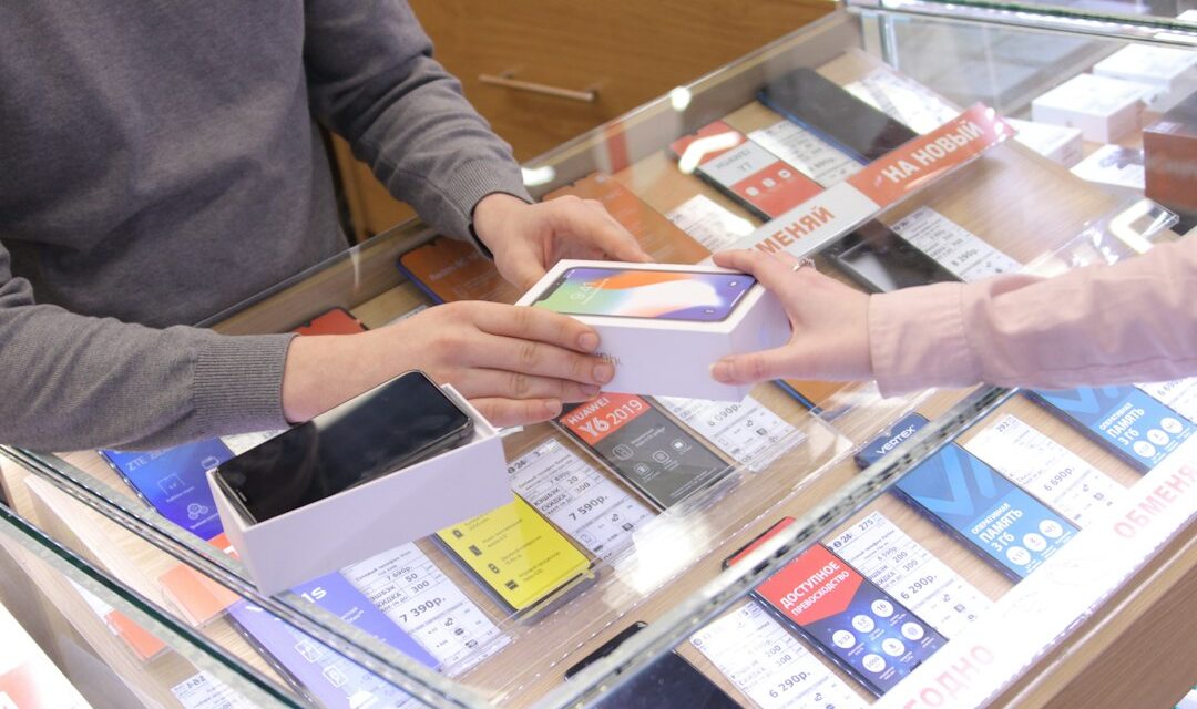 A man and a woman exchanging a cell phone at a store