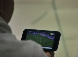 A man is playing a soccer game on his phone