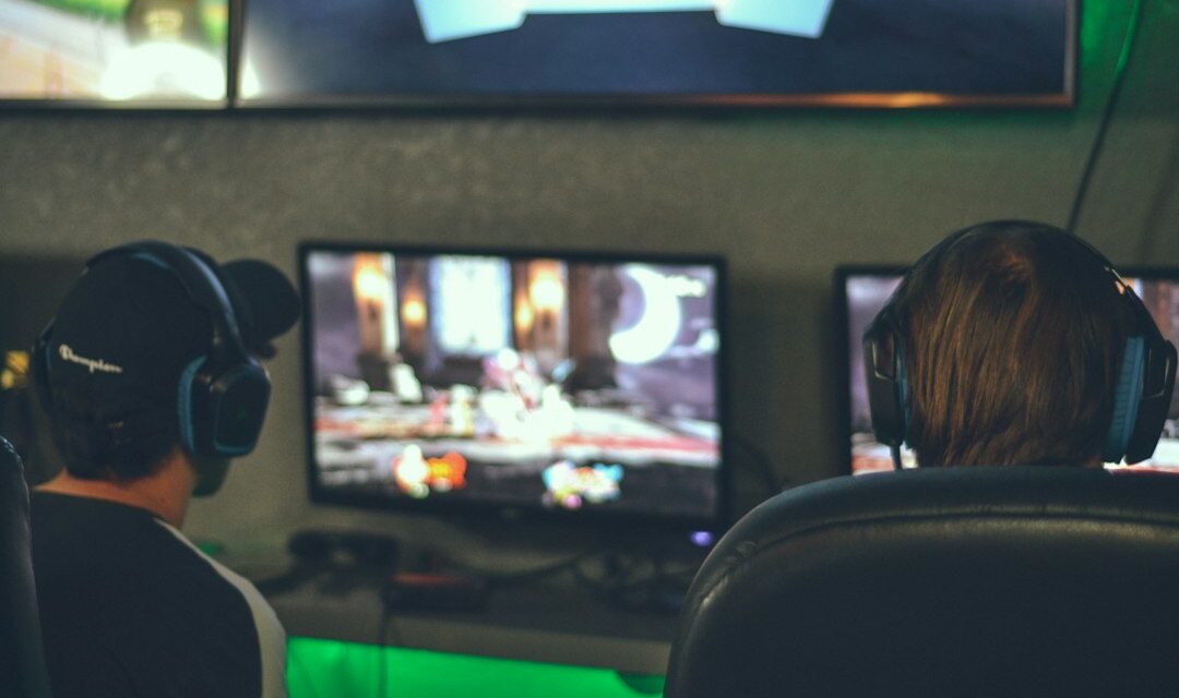 Selective focus photography of two persons playing game in front of monitors
