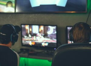 Selective focus photography of two persons playing game in front of monitors