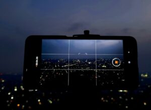 A person taking a picture of a city at night