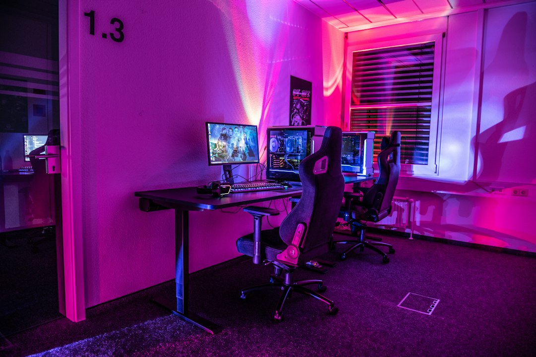 A room with a desk, computer, and two monitors
