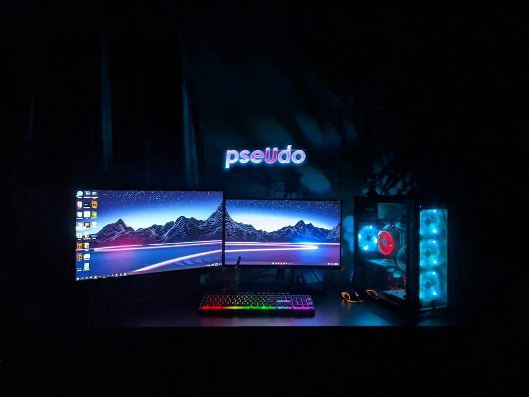 Black flat screen computer monitor turned on with black computer keyboard