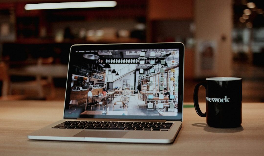 A laptop with a coffee cup