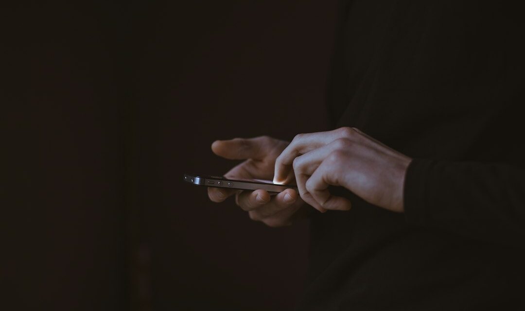 Silhouette photo of person holding smartphone