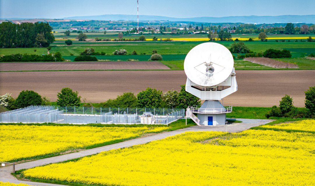 A satellite dish sits amidst fields