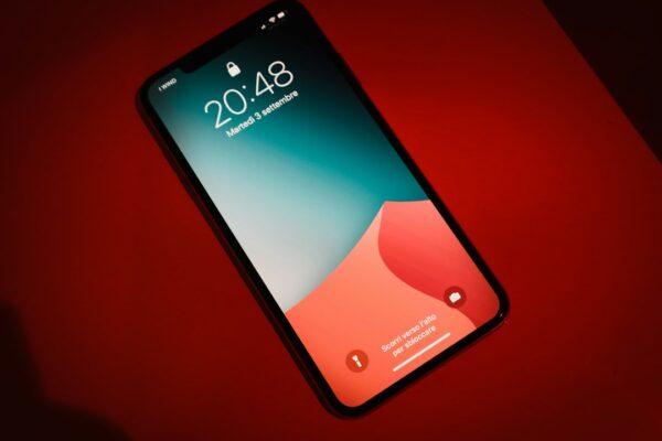 A close up of a cell phone on a red surface