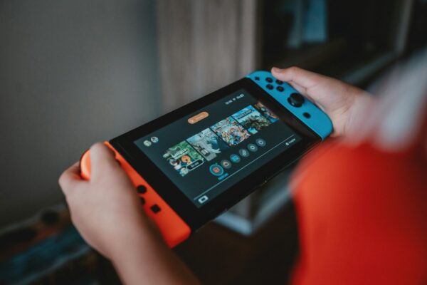 Person holding black and orange nintendo switch