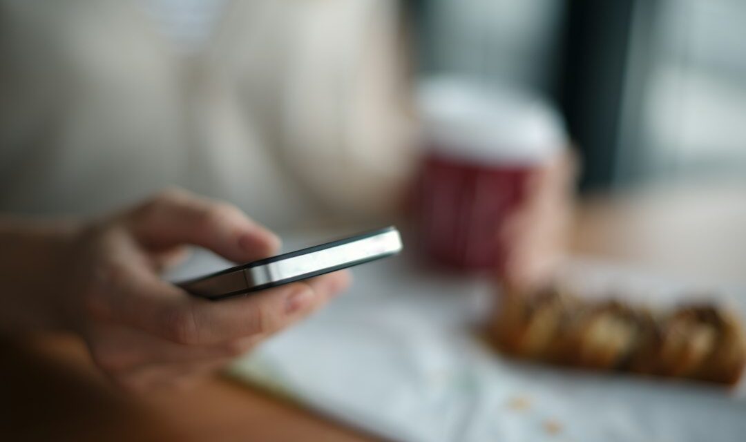 Selective focus photography of person holding gray phone