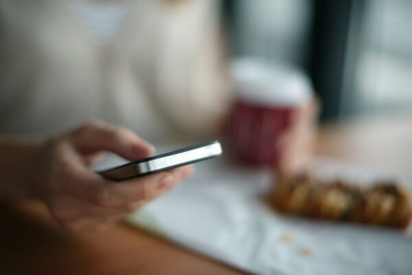 Selective focus photography of person holding gray phone