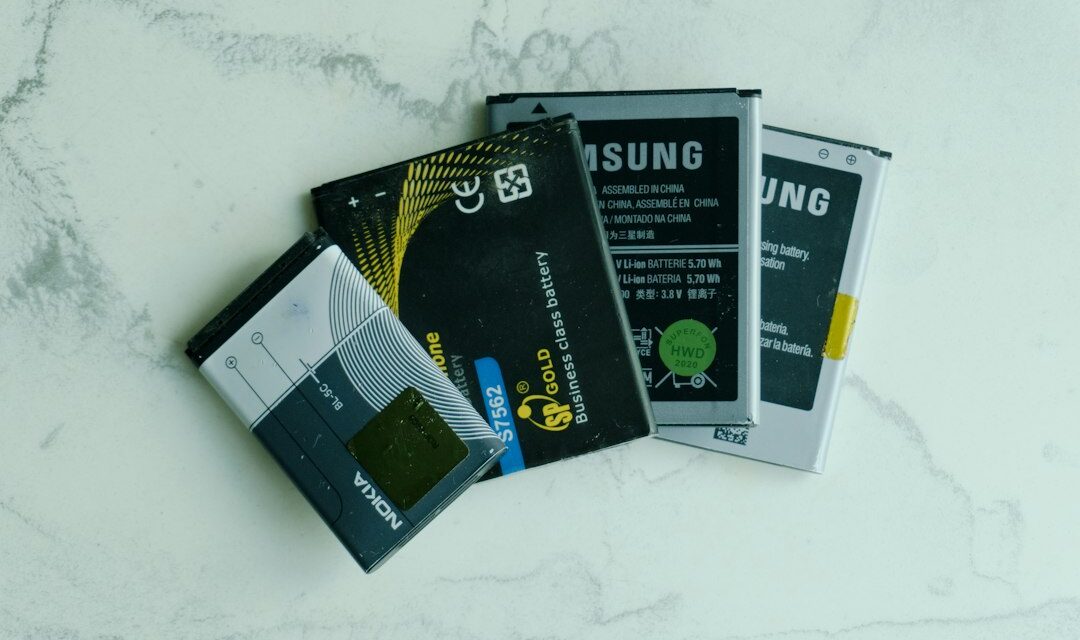 Several old mobile phone batteries on a white surface