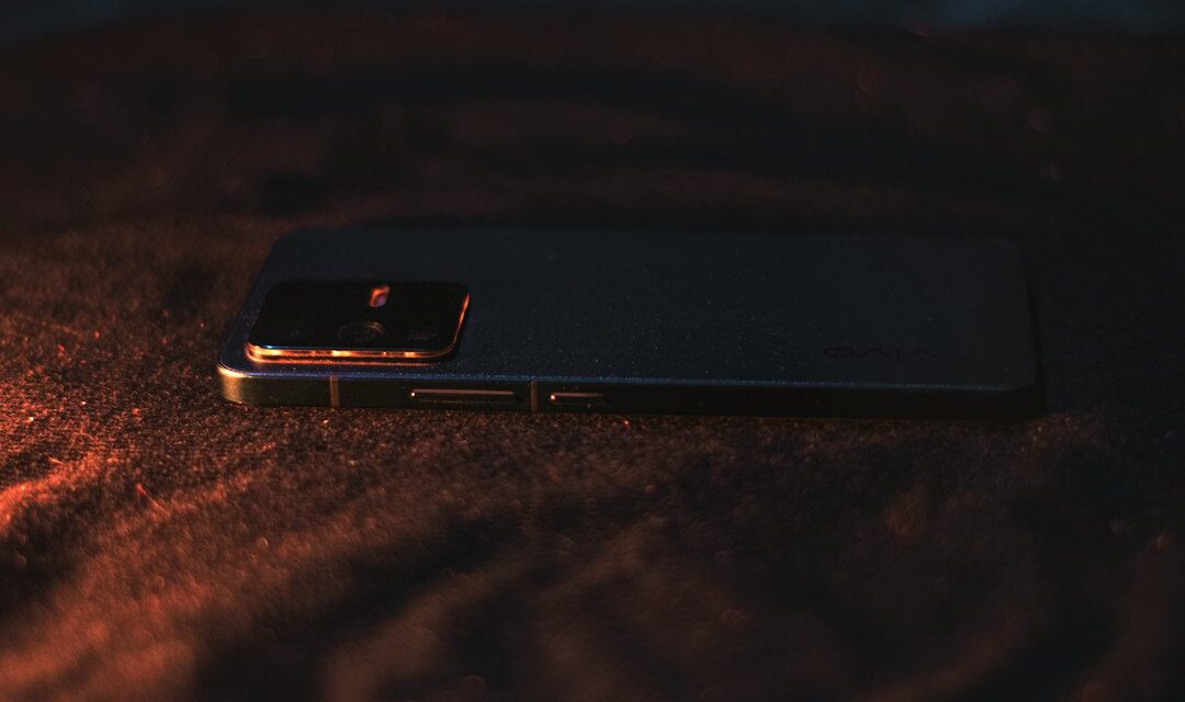 A close up of a cell phone on a bed