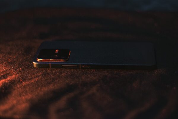 A close up of a cell phone on a bed