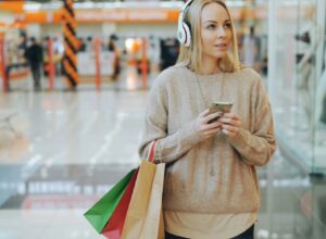 Woman with headphones and shopping bags in mall