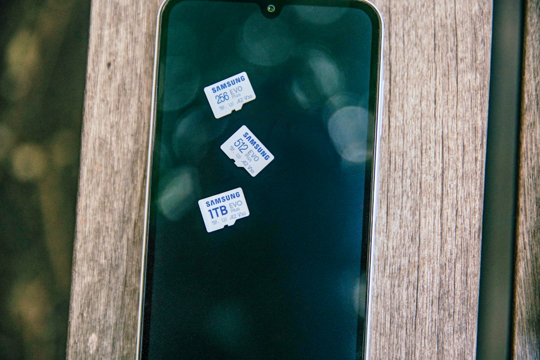 A green cell phone sitting on top of a wooden table