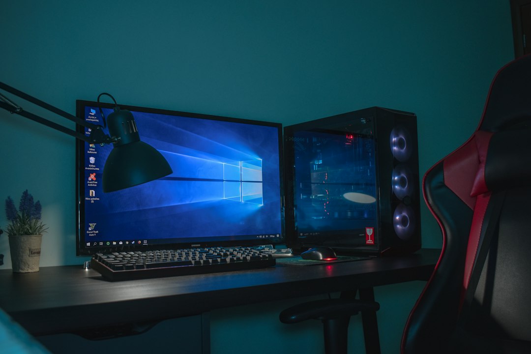 Turned on desktop computer set with black and gray leather gaming chair