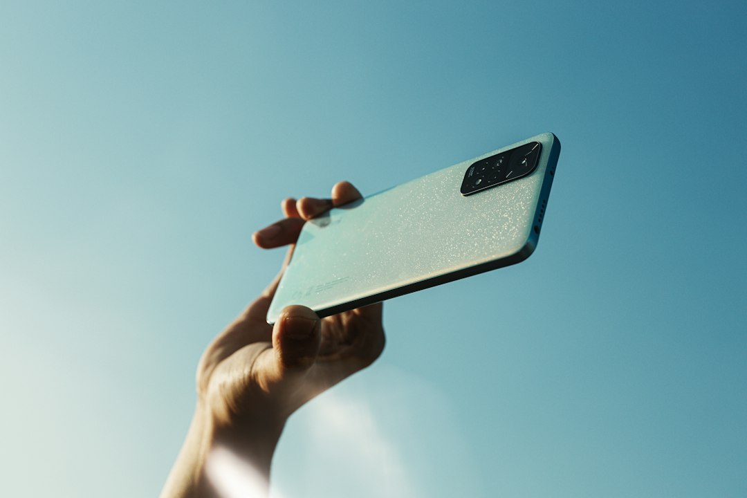 A person holding a cell phone up in the air