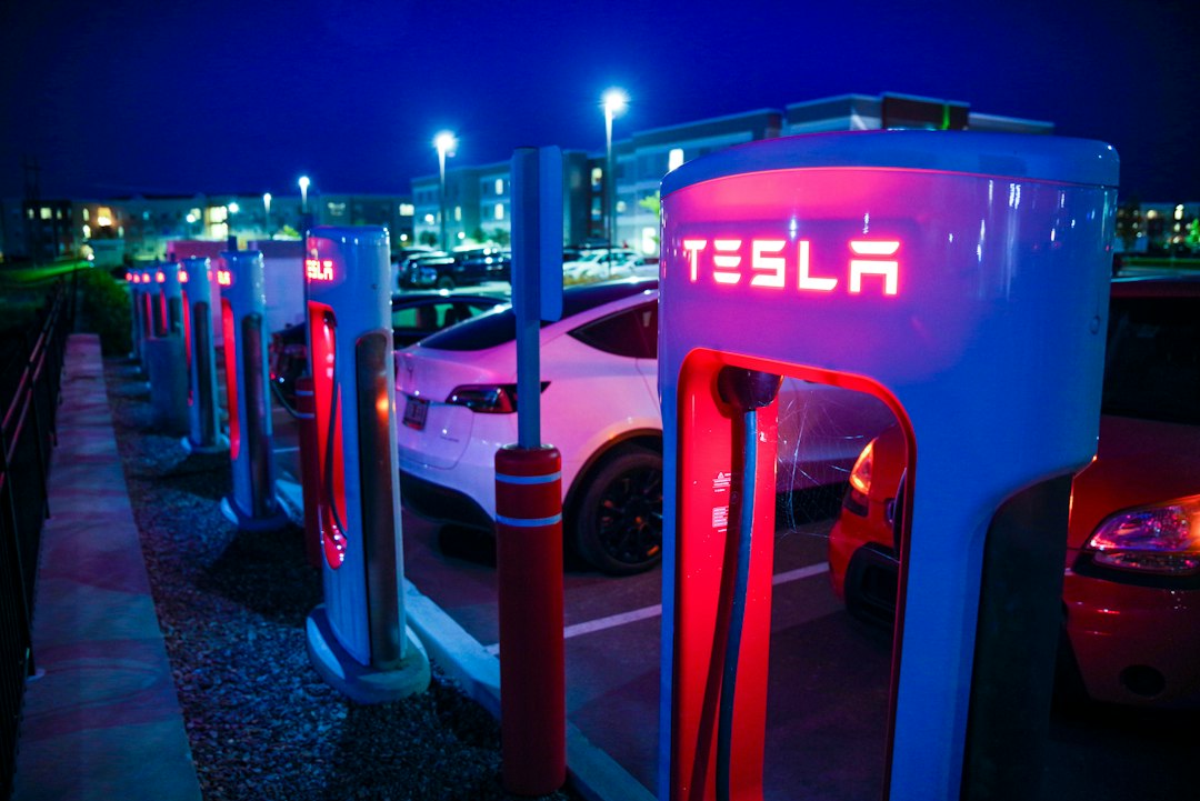 A row of tesla charging stations at night