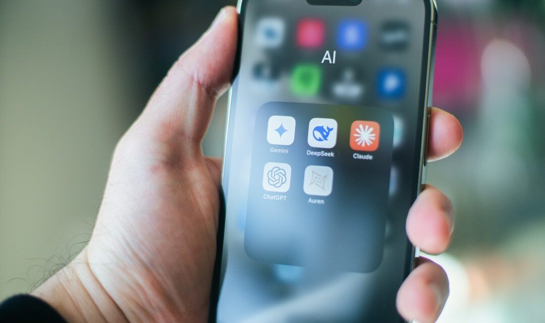 A hand holds a smartphone with various apps