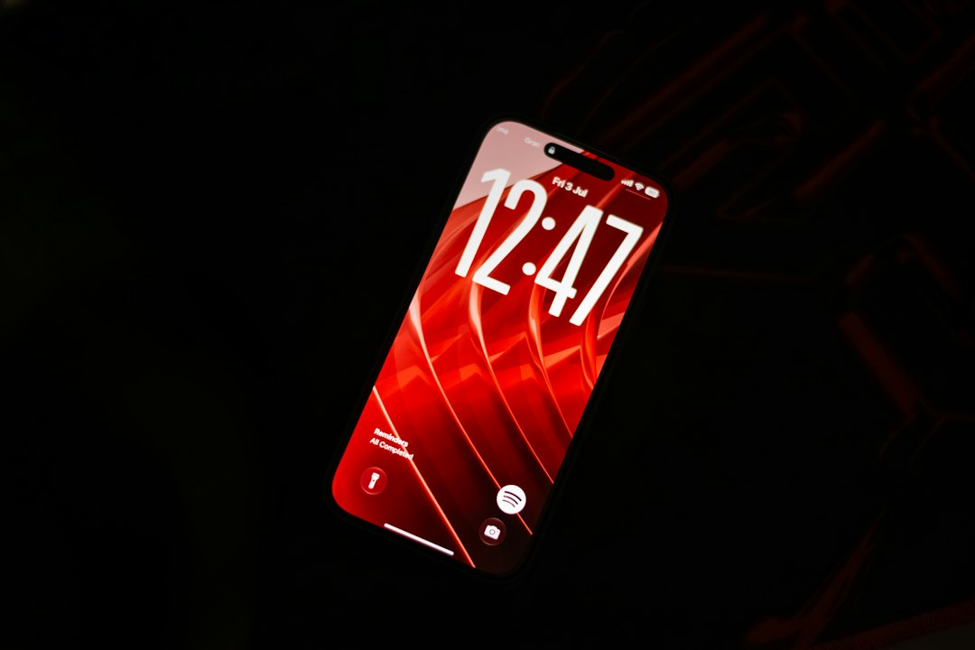 A smartphone with a red screen displaying the time 12:47